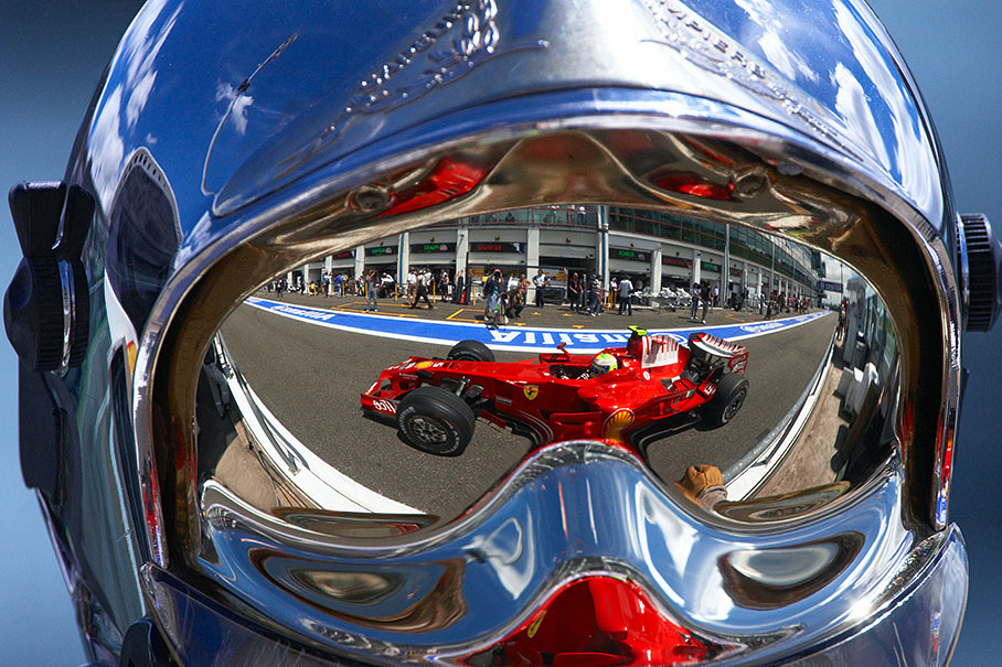 Ferrari driver Felipe Massa, as a reflection in a firemarshal's helmet visor