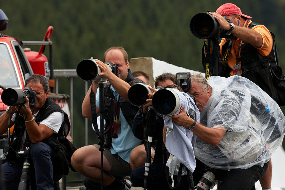 Photographers wait for incoming cars at pitlane entrance