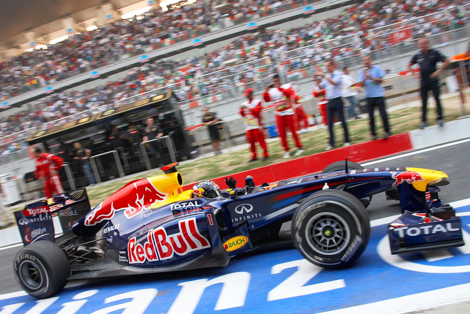 Race winner Sebastian Vettel of Red Bull Racing arrives at parc ferme after his honoury lap