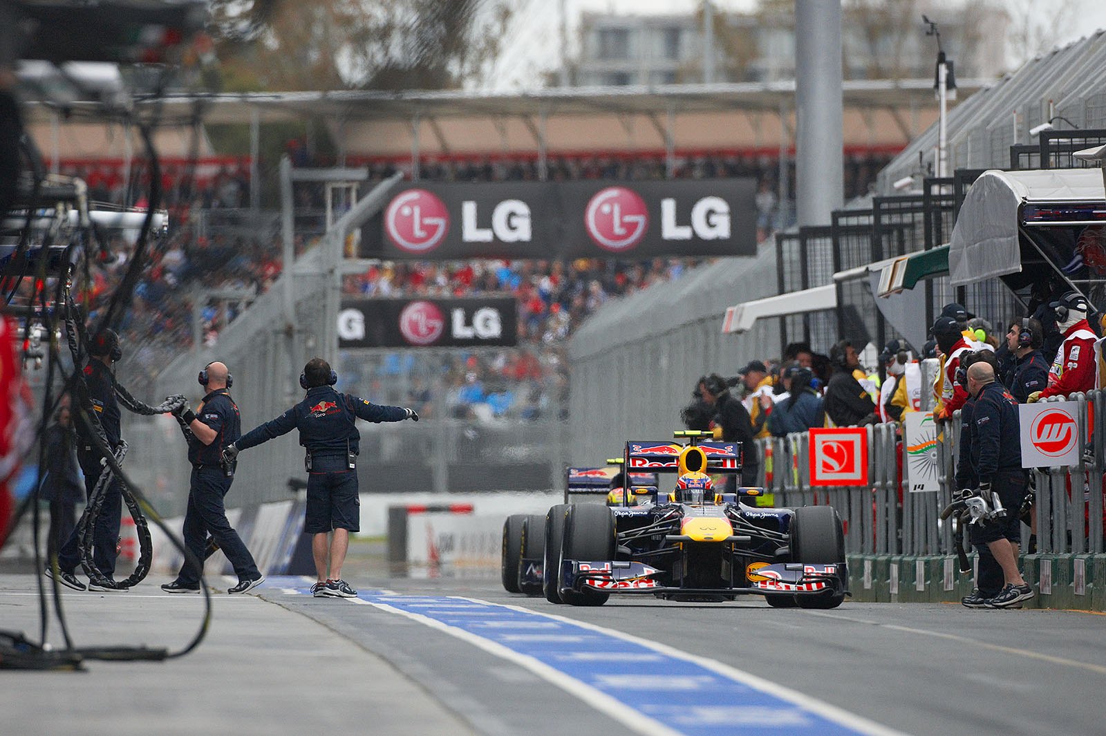 Mark Webber rolls through pit lane in front of Toro Rosso driver Alguersuari