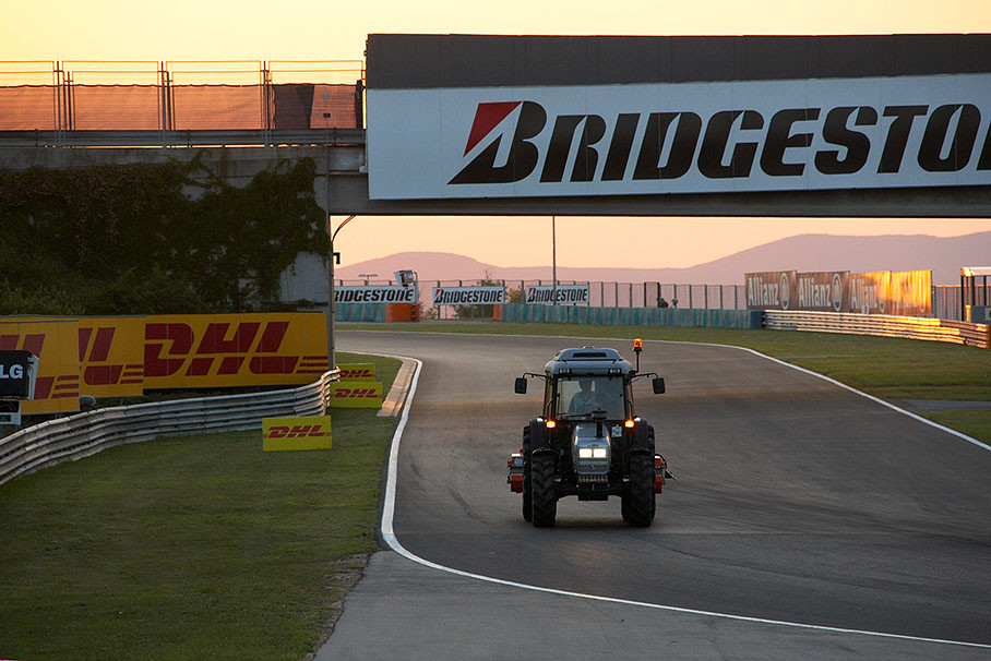 A lonely cleaning tractor enters turn 2 on Thursday evening