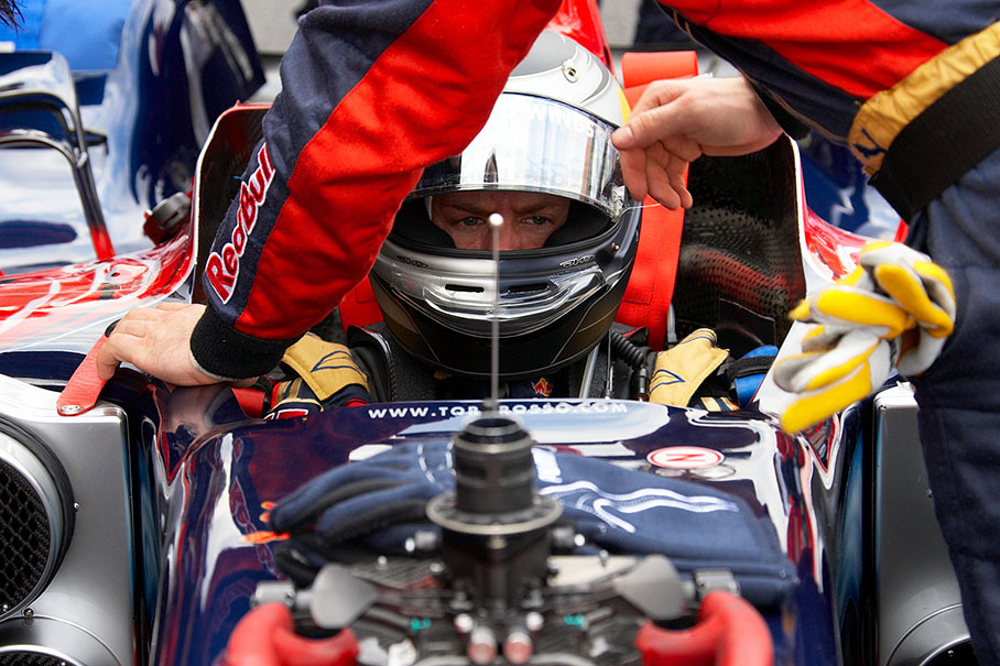 Sebastian Vettel takes a seat in the Toro Rosso car shortly before the race