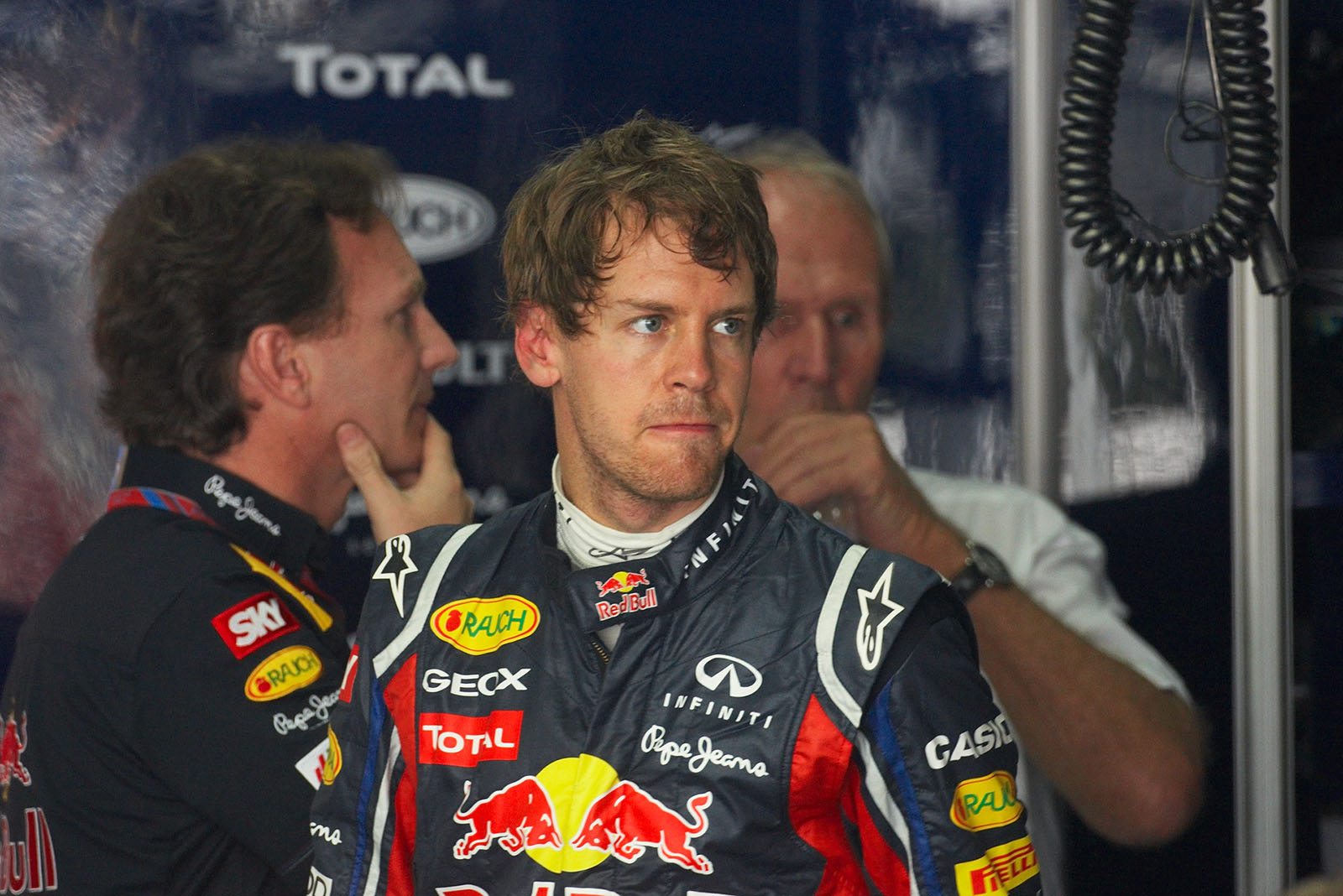 A thoughtful Sebastian Vettel in pits with Red Bull's Horner and Marko