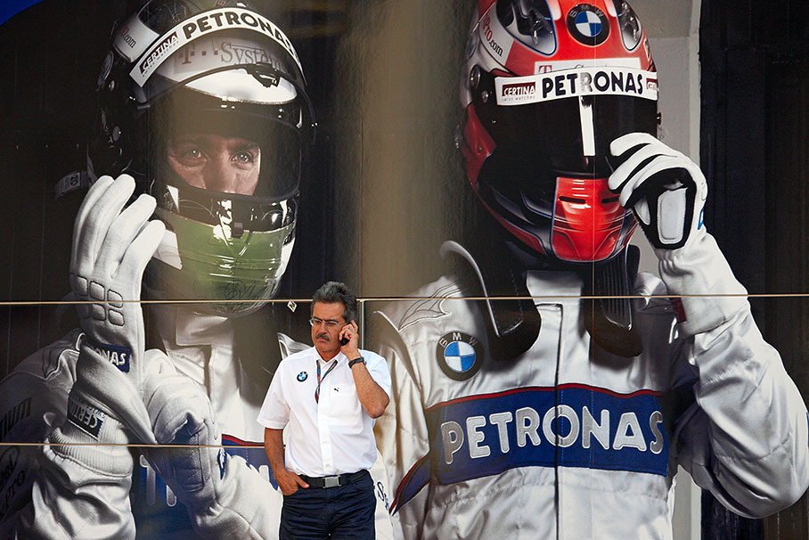 BMW Motorsport Director Prof. Dr. Mario Theissen telephones besides a team transporter