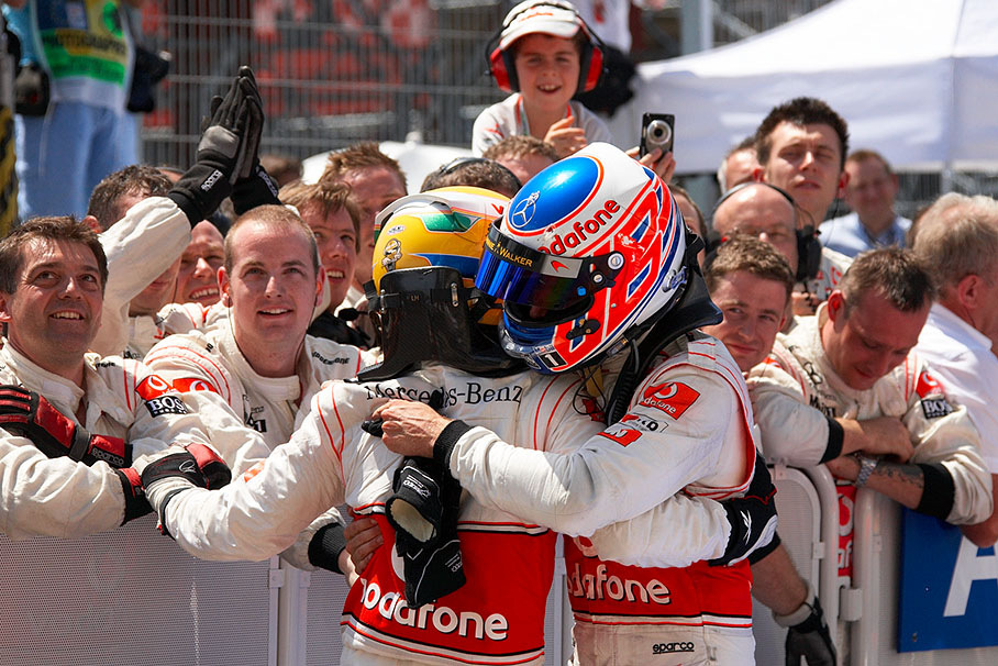 Second placed Hamilton hugs third placed Button in parc ferme in front of the McLaren crew
