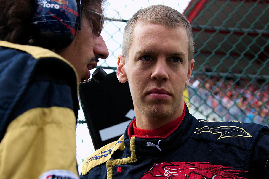Toro Rosso driver Sebastian Vettel listens to an engineer