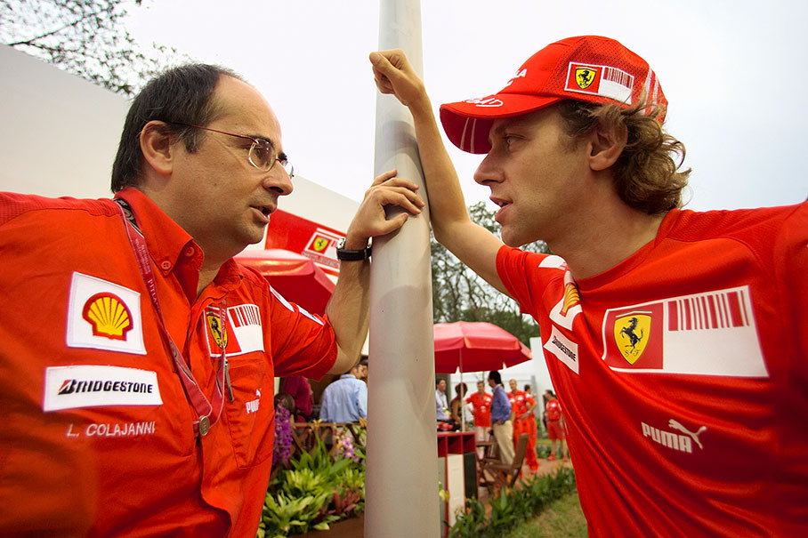 Ferrari press officer Luca Colajanni speaks to Ferrari test driver Luca Badoer
