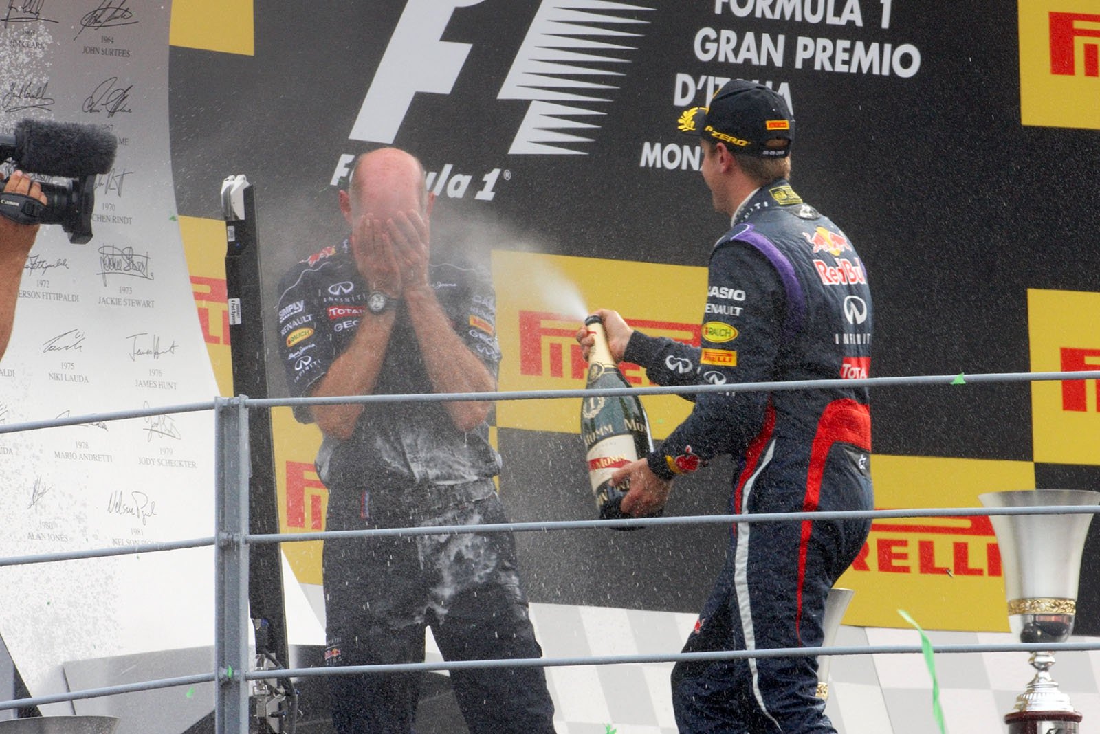 RBR's race winner Sebastian Vettel sprays champagne at Adrian Newey during the podium ceremony after the Italian Grand Prix in Monza 2013