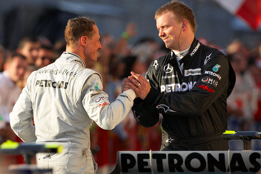 Michael Schumacher shakes hands with a Mercedes engineer after the race