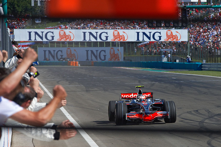 Kovalainen passess the cheering McLaren mechanics with a raised fist