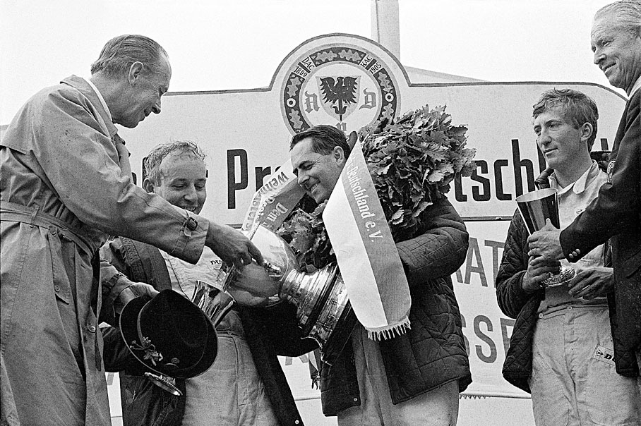 Freiherr von Diergardt presents Jack Brabham with the winners trophy, watched by second placed John Surtees, whilst Fuerst von Metternich hands Jochen Rindt &#13;his cup for third place.