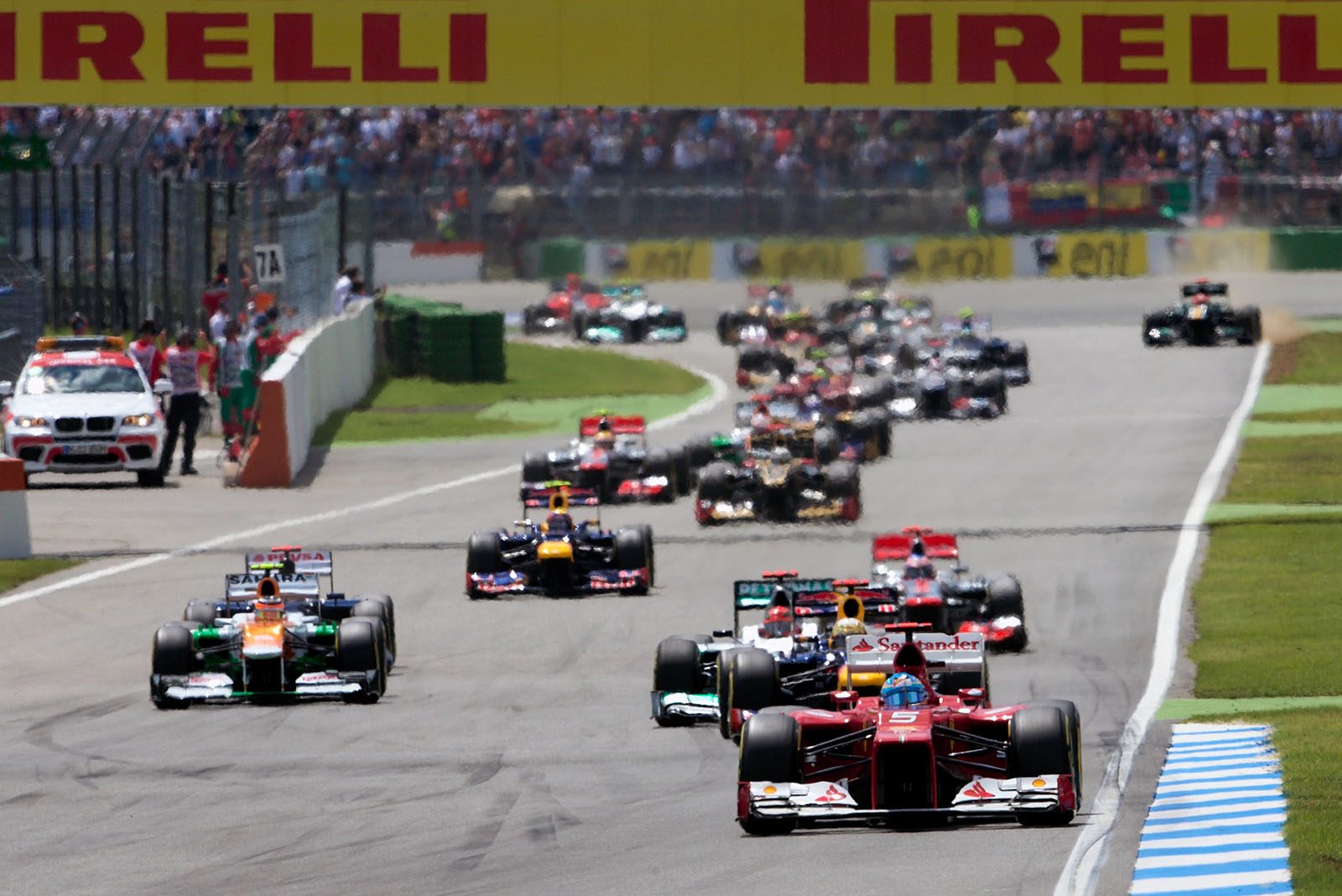 The start field with Ferrari's Alonso in the lead approaches turn two