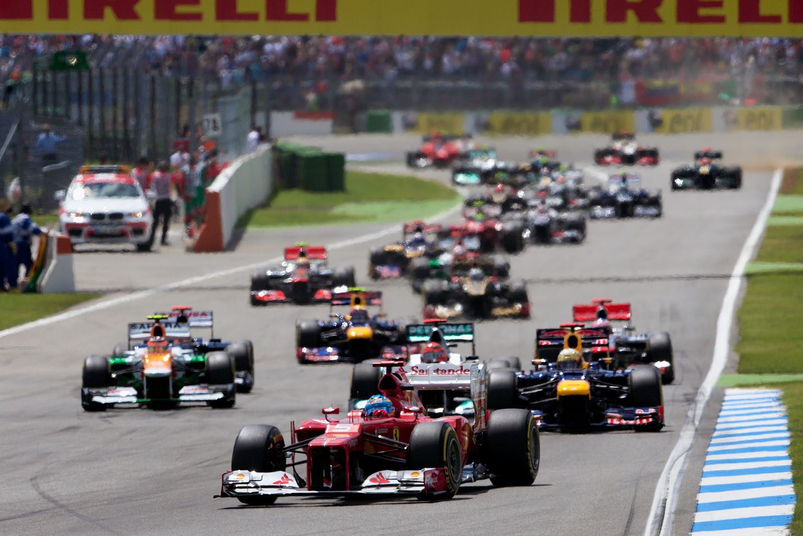 The start field with Ferrari's Alonso in the lead approaches turn two