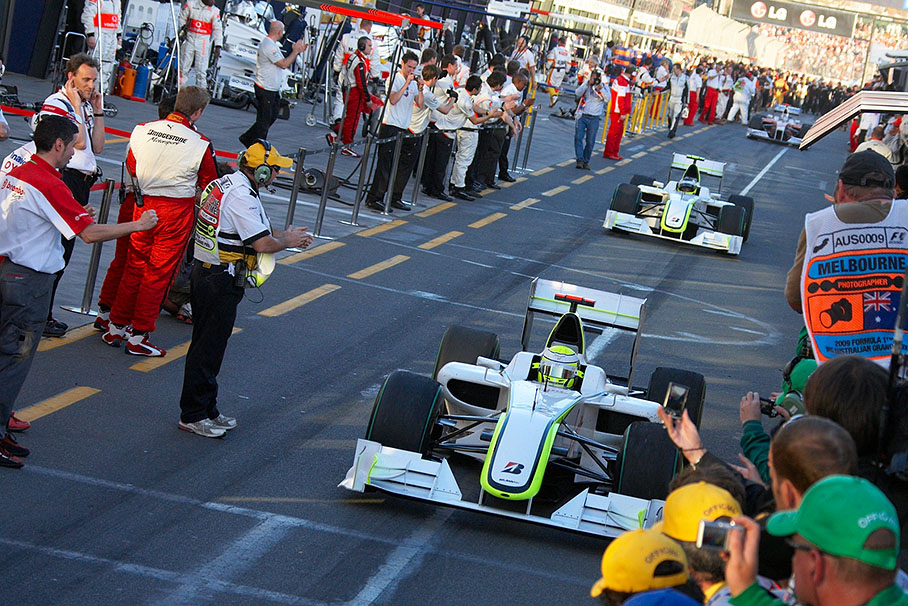 The two winning Brawn GP drivers Button and Barrichello arrive at parc ferme for the podium ceremony, followed by (still) third classified Trulli