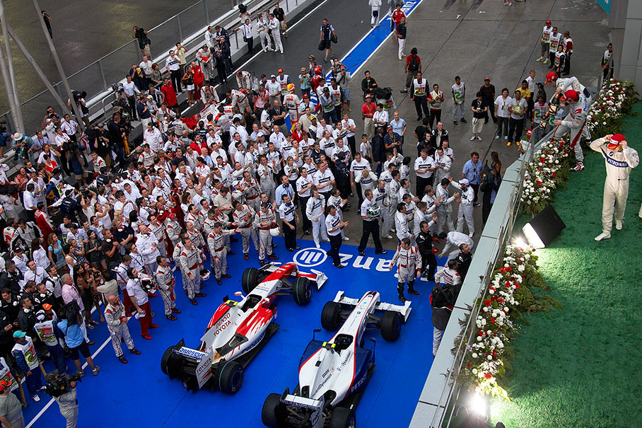 Glock's Toyota and Heidfeld's BMW Sauber in parc ferme after the abandoned race, surrounded by their team crews during podium ceremony