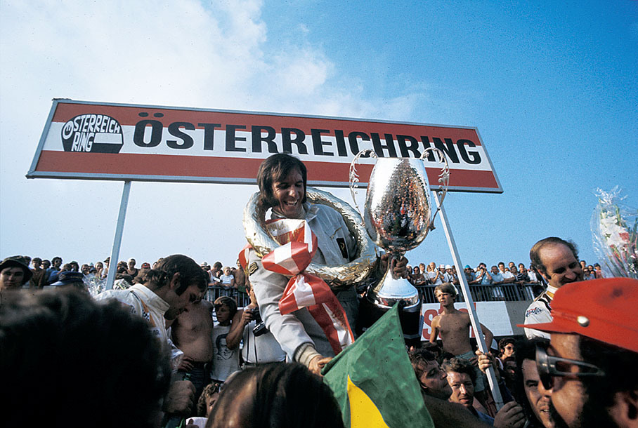 Emerson Fittipaldi celebrates his win on the podium after the Austrian GP 1972