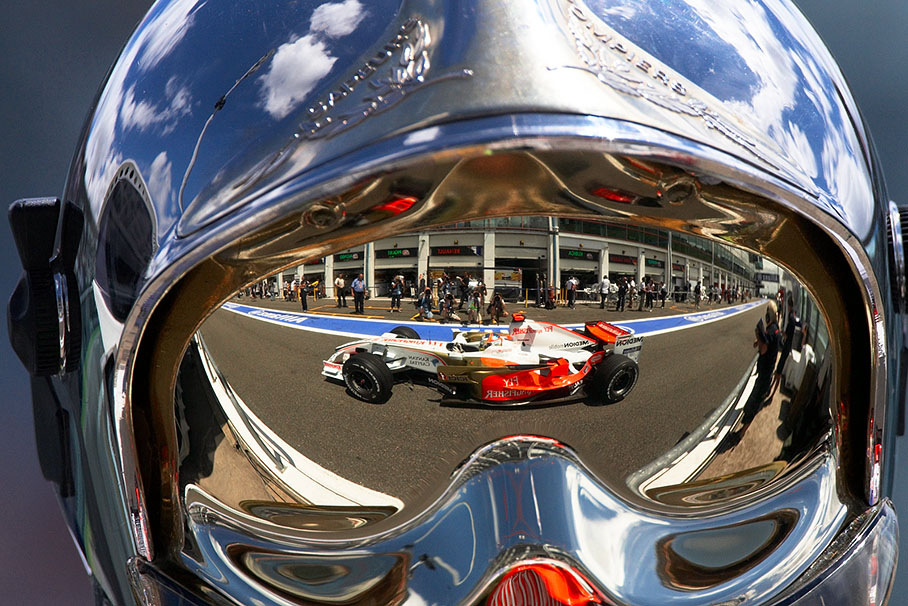 Adrian Sutil of Force India, as a reflection in a firemarshal's helmet visor