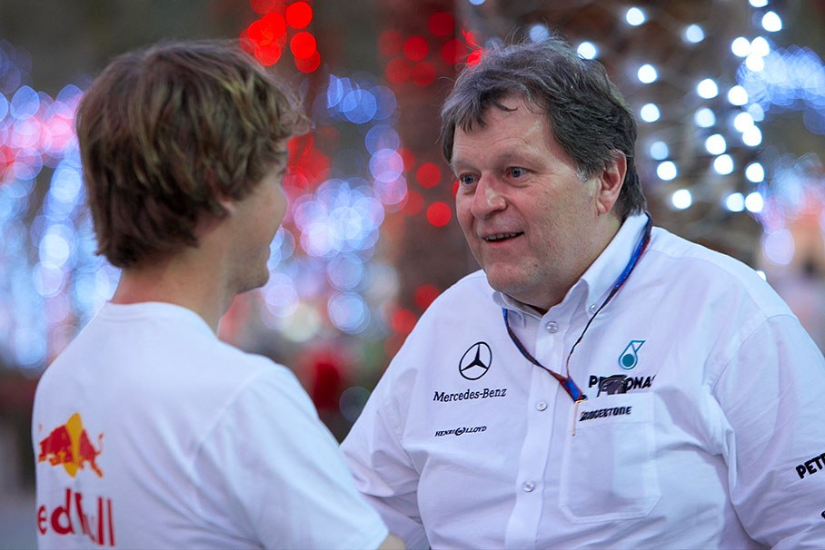 Sebastian Vettel and Mercedes Motorsport director Norbert Haug have a chat in the illuminated paddock