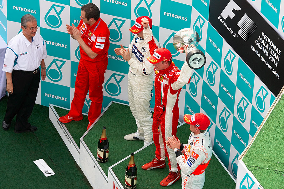 Winner Kimi Raikkonen raises his trophy