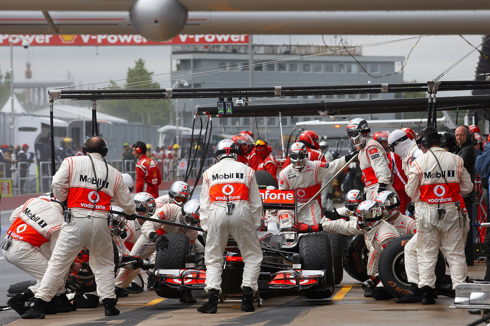 Jenson Button is briefly serviced at McLaren pits