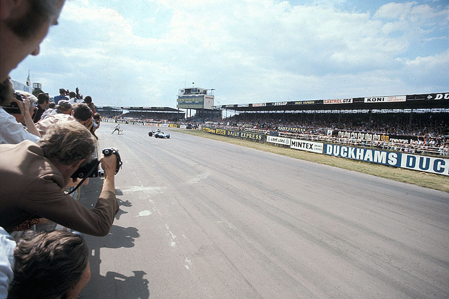 Race winner Jackie Stewart on Tyrrell-Cosworth 003 takes the chequered flag after the British GP in Silverstone 1971