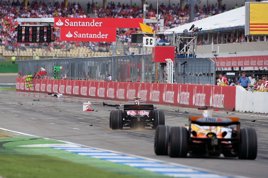 Vettel and Alonso navigate through the Toyota's carbon fibre debris