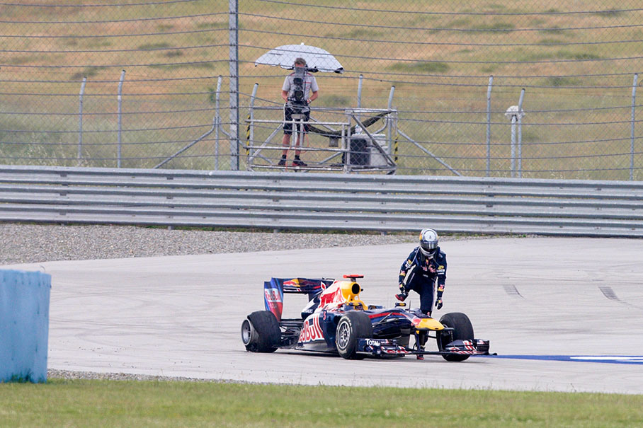 Sebastian Vettel climbs out of the car after the collision with team mate Webber