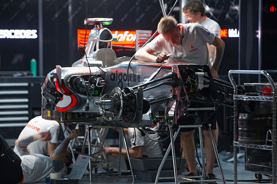 Mechanics work on Hamilton's McLaren-Mercedes in pits