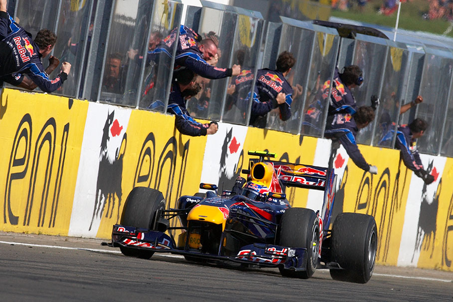 Mark Webber passes his cheering Red Bull Racing team