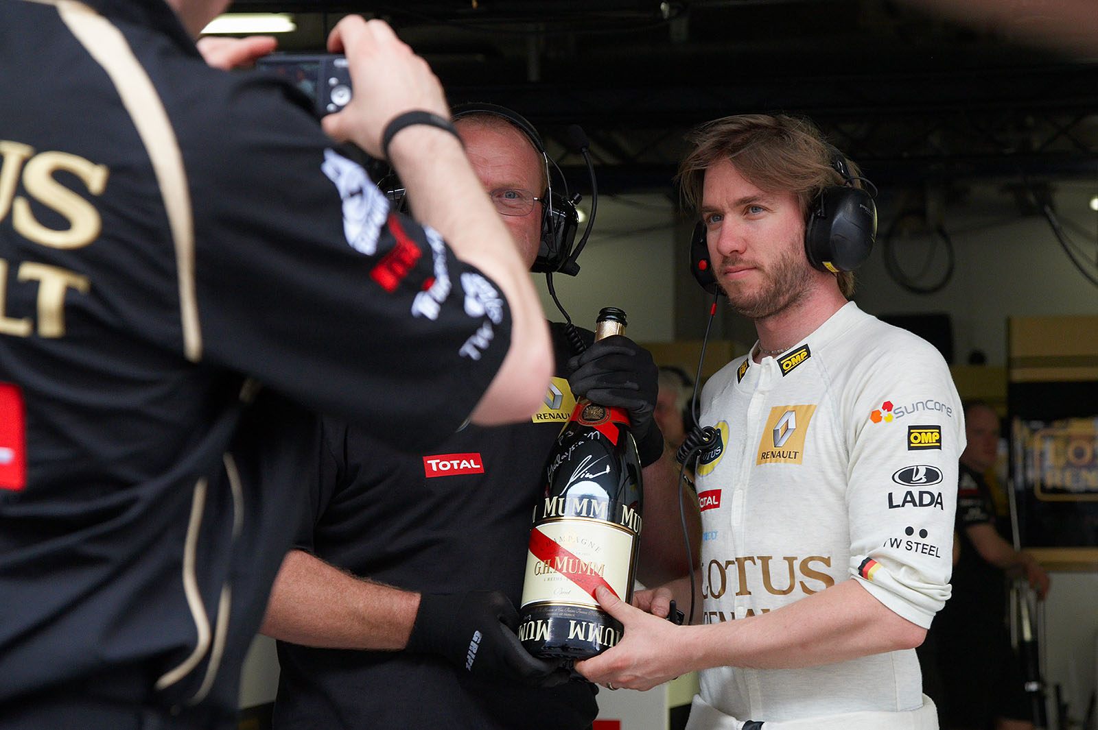 Nick Heidfeld presents the champagne bottle for his third place at the previous race in Sepang in Lotus Renault pits