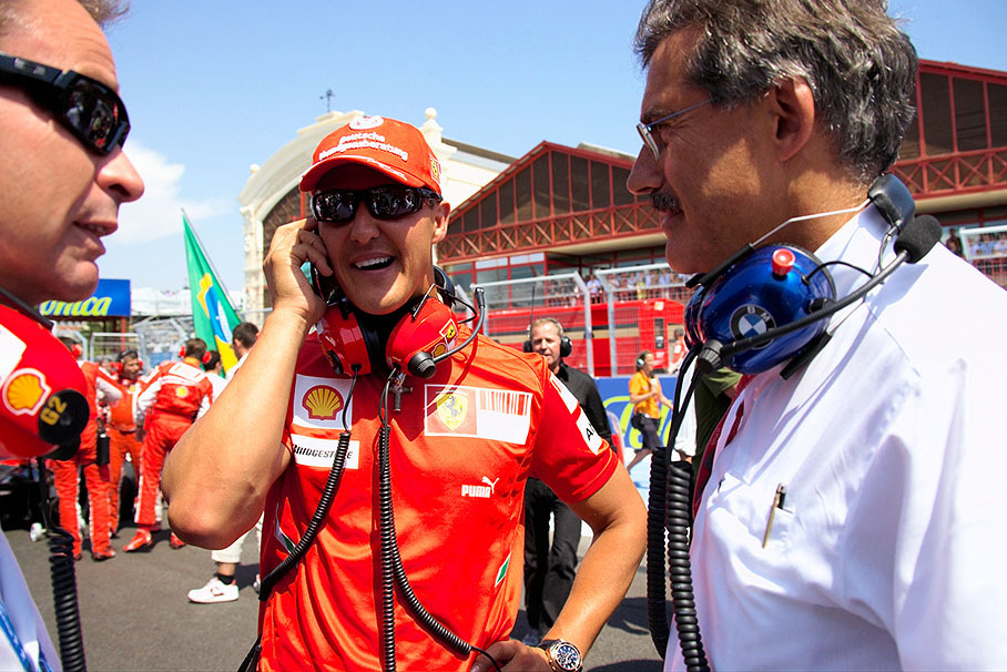 BMW Motorsport director Dr. Mario Theissen's chat with famous guest Michael Schumacher is being interrupted by a busy mobile phone