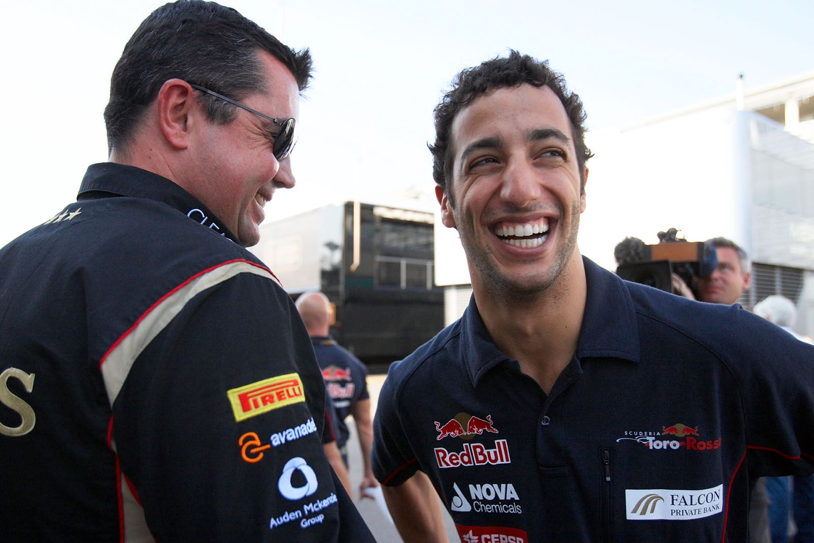 Daniel Ricciardo of Toro Rosso jokes around with Lotus team boss Eric Boullier