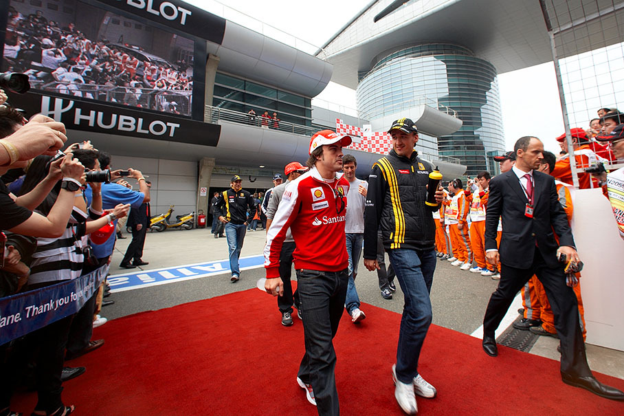 Fernando Alonso and Robert Kubica walk to drivers parade