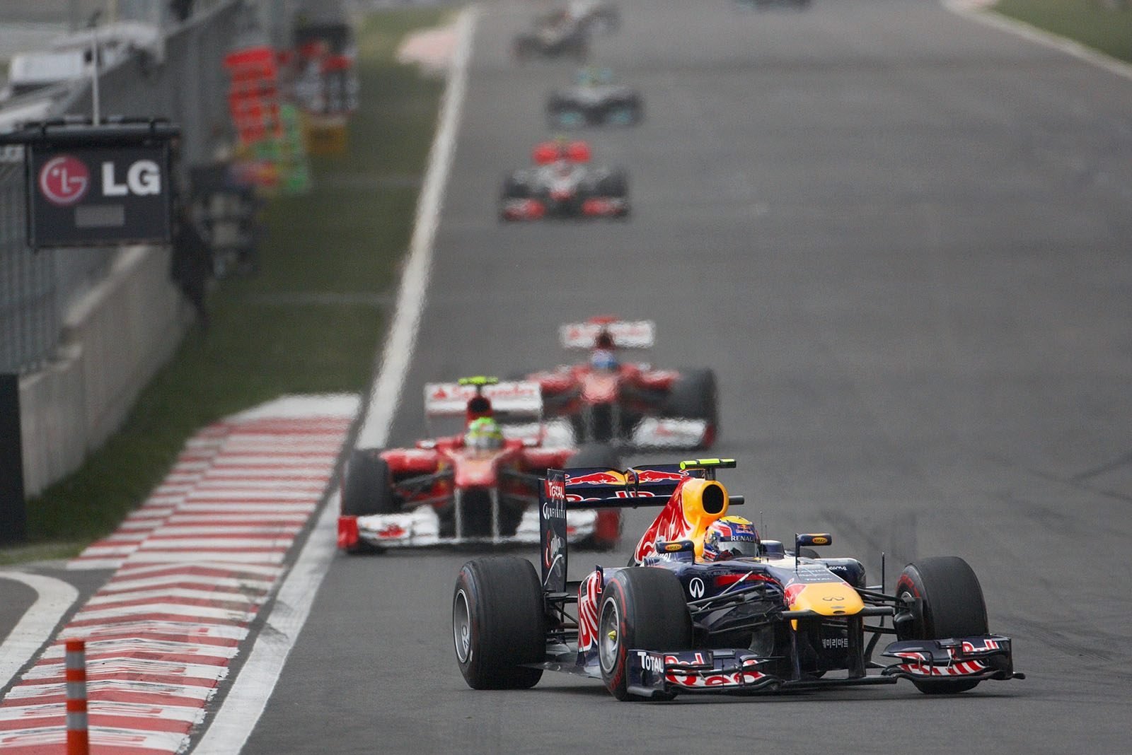 Mark Webber, Red Bull Racing, in front of the two Ferrari cars