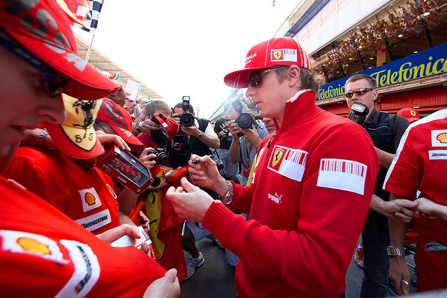 Ferrari driver Kimi Raikkonen signs autographs