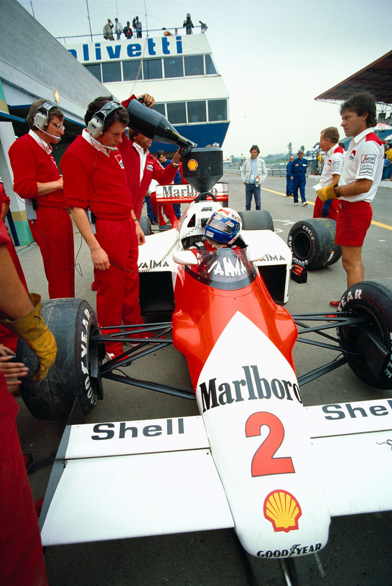 Alain Prost, McLaren-TAG Porsche driver, in pits alking to designer John Barnard