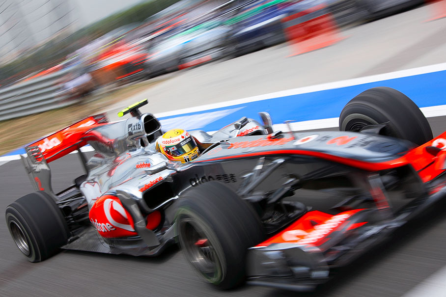 Lewis Hamilton comes to McLaren pits with two flat rear tyres