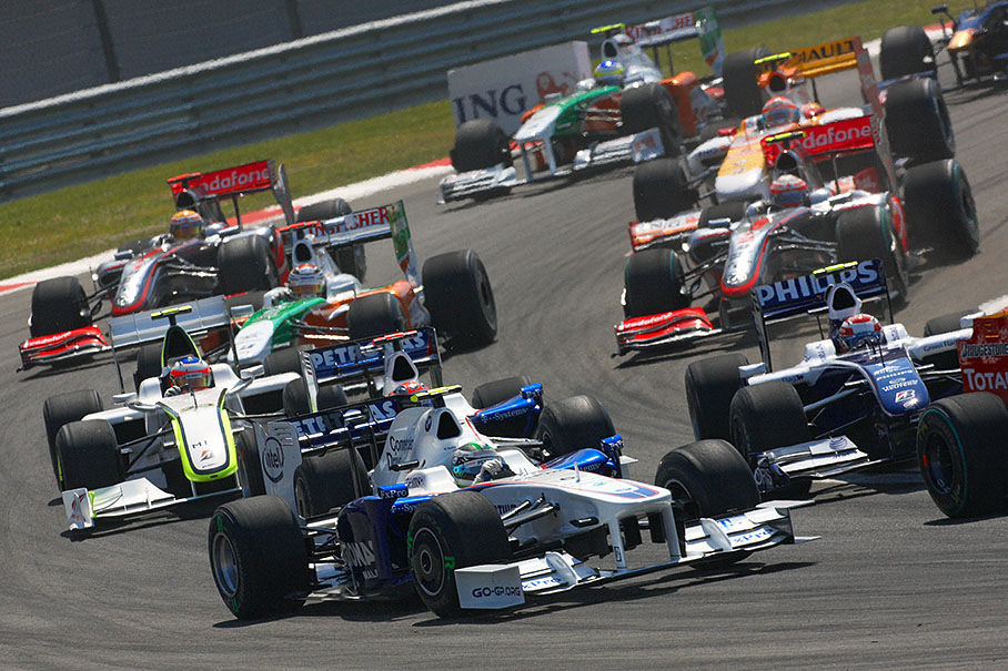 The start field passes turn one, Heidfeld in focus