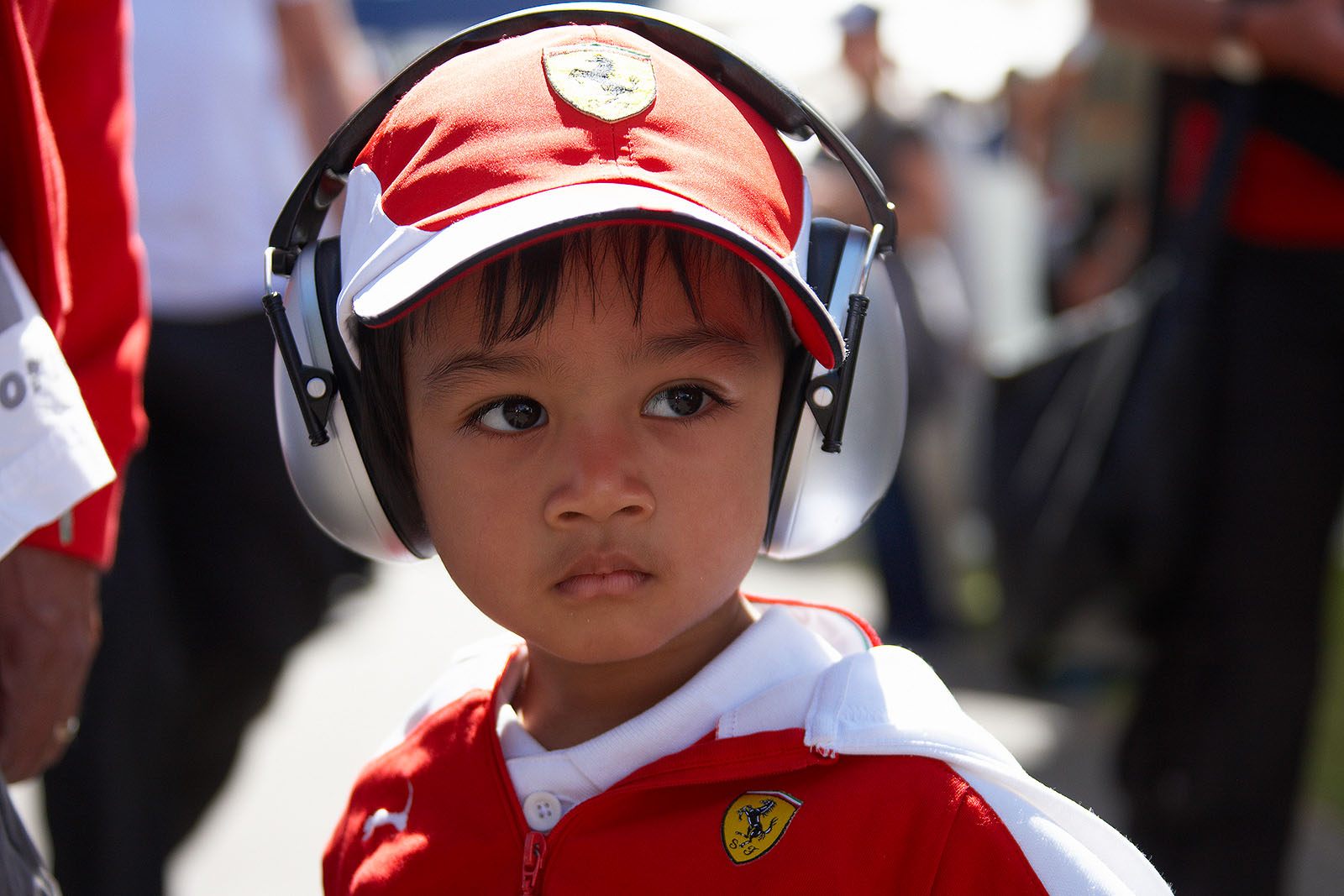 A young Ferrari fan wearing ear protection