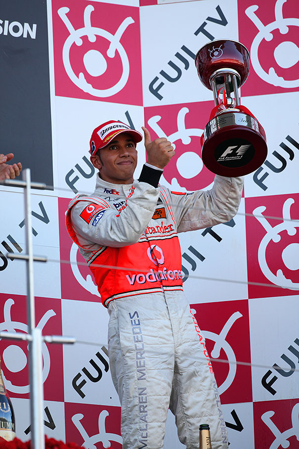 Third placed Lewis Hamilton raises his shiny trophy