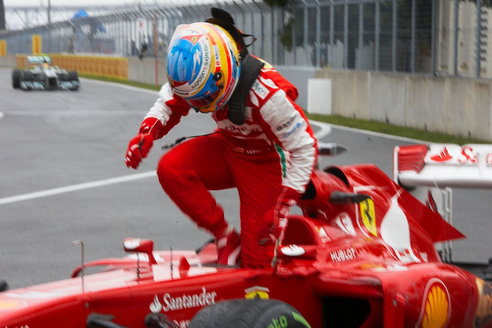 Fernando Alonso exits his Ferrari race car after qualifying sixth