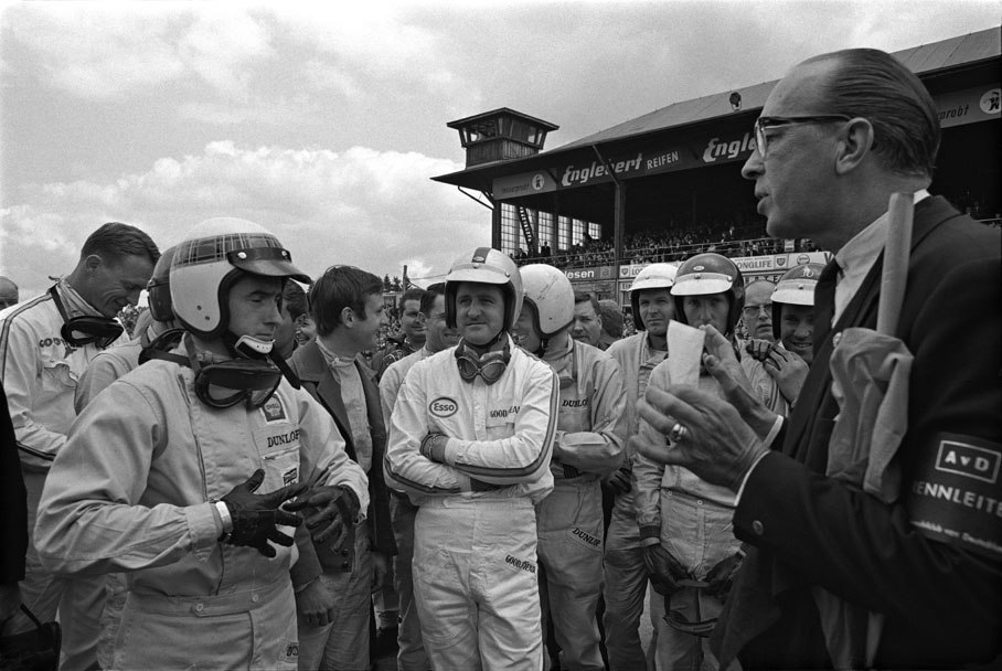 Freiherr von Diergardt tries to brief a disinterested bunch of drivers, who are not listening to a word he is saying (fltr.: Dan Gurney, Jackie Stewart, Chris Amon, Denny Hulme, Mike Spence, Frank Gardner, Jochen Rindt, Paul Hawkins).