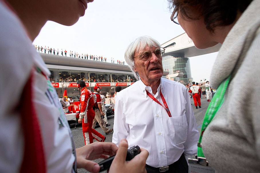 Bernie Ecclestone speaks with VIP guests on the grid