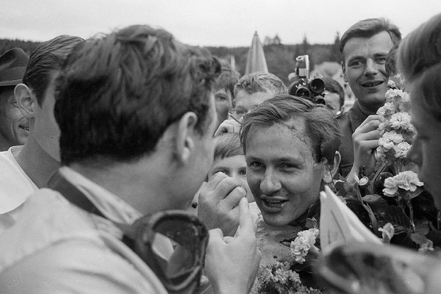 Bruce McLaren, second placed of the Belgian GP 1964, gesticulates with winner Clark after the podium ceremony.