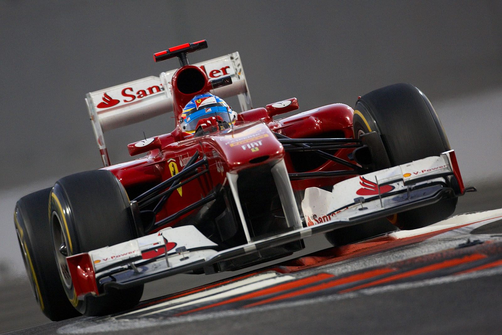 Fernando Alonso's Ferrari flies over the curbs