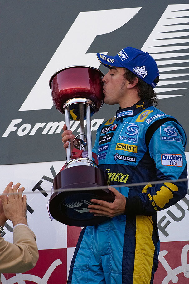 Fernando Alonso kisses his winner's trophy