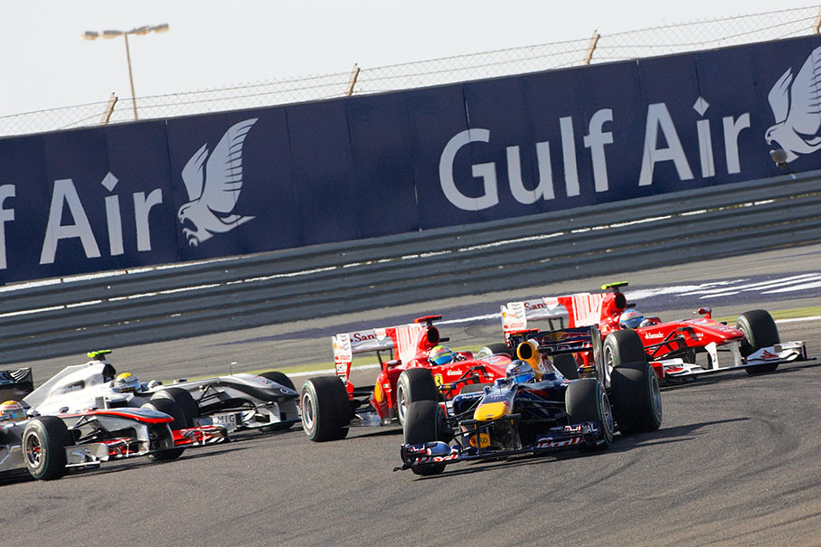 The start field springs into first corner, polestarter Vettel still in front with both Ferraris in the neck