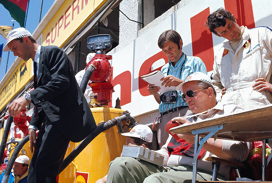 Porsche's legendary engineer Helmuth Bott takes the times, Ferdinand Piech is about to jump from the pitwall. Journalist Helmut Zwickl stands in the middle while Porsche driver Brian Redman reads the schedules.