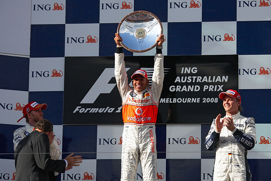 Race winner Lewis Hamilton presents his first place trophy.