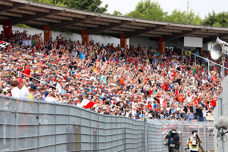 Whilst photographers rush from grid to first corner, fans do the la ola wave